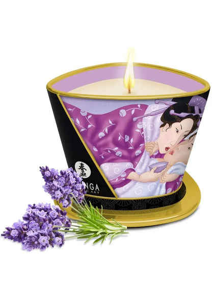 Massagekaars Shunga met kaarsvlam, paarse illustratie op zwarte houder, goudkleurige voet en lavendelbloemen.
