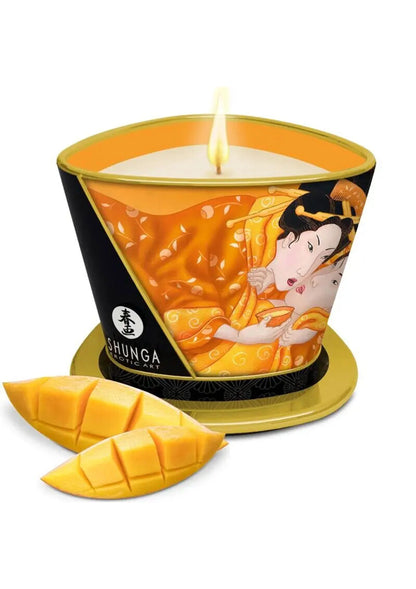 Massagekaars Shunga met kaarsvlam, oranje illustratie, zwarte houder, goudkleurige voet en mango-stukjes.