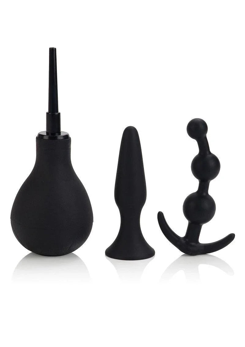 Black anal hygiene and pleasure kit including enema bulb, smooth butt plug, and beaded anal plug on white background