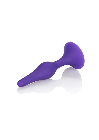 Purple silicone butt plug with ergonomic shape on white reflective surface