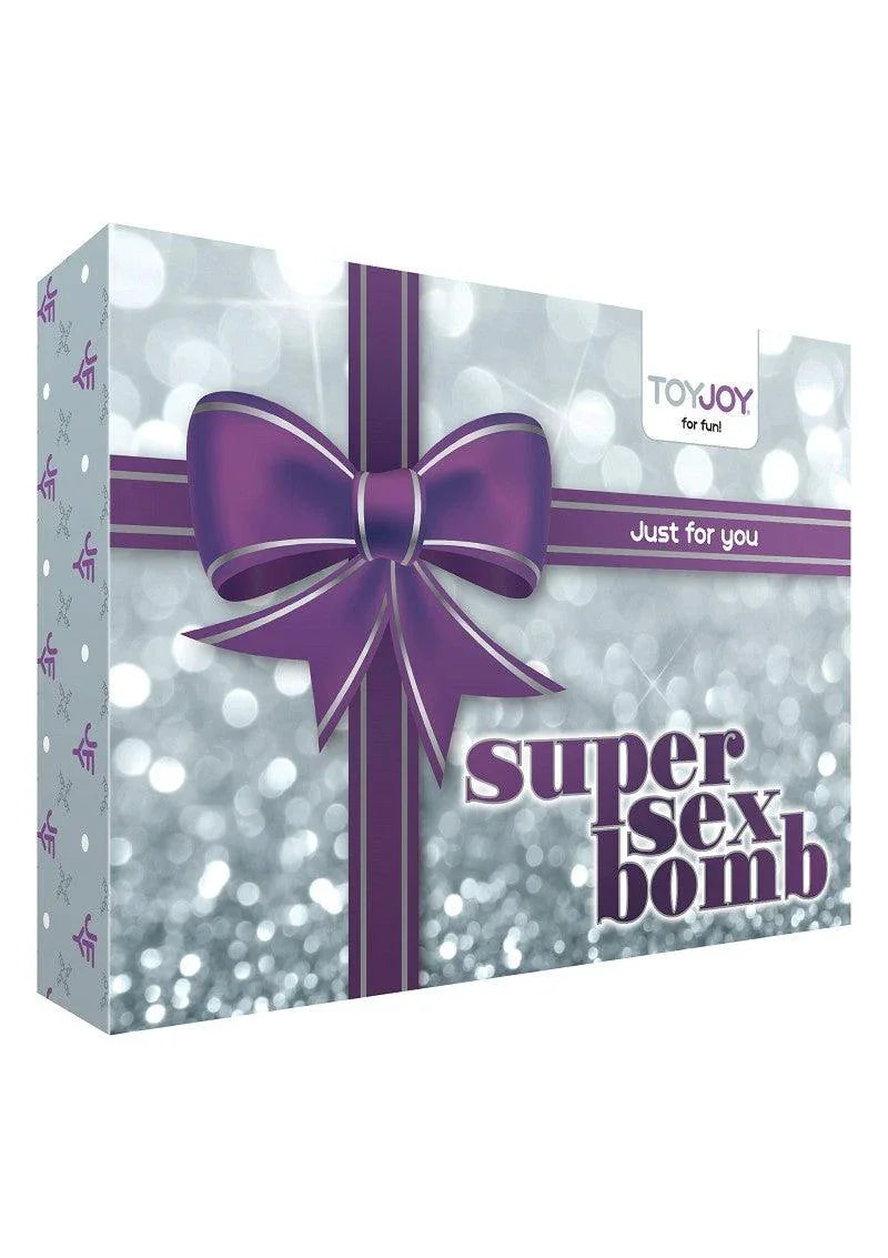 Gift box with purple bow labeled Super Sex Bomb by ToyJoy for fun, silver sparkly background